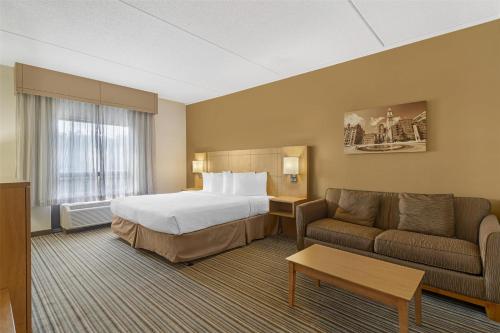 a hotel room with a bed and a couch at Best Western Royal Plaza Hotel and Trade Center in Marlborough