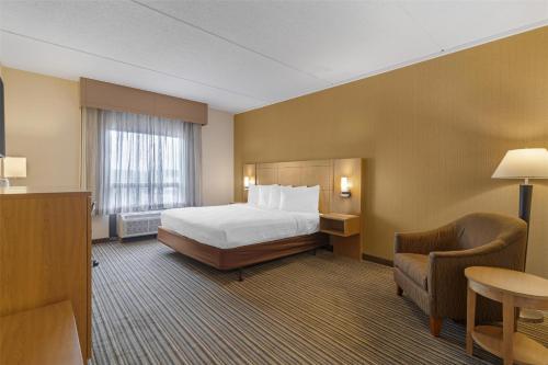 a hotel room with a bed and a chair at Best Western Royal Plaza Hotel and Trade Center in Marlborough
