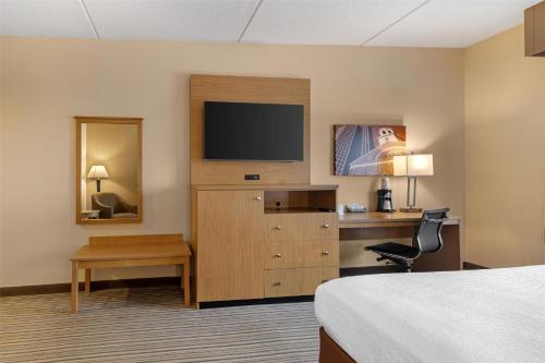a hotel room with a bed a desk and a television at Best Western Royal Plaza Hotel and Trade Center in Marlborough