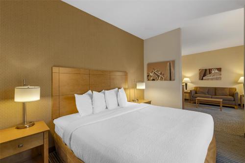 a hotel room with a large bed and a living room at Best Western Royal Plaza Hotel and Trade Center in Marlborough