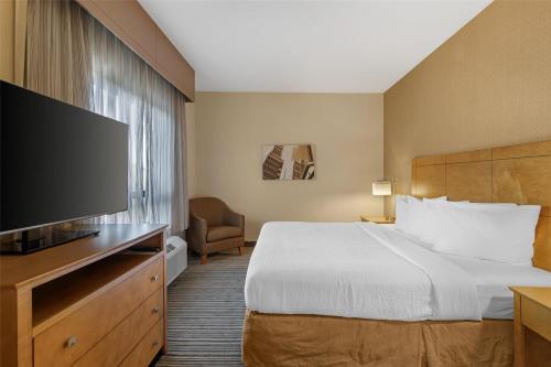 a hotel room with a bed and a flat screen tv at Best Western Royal Plaza Hotel and Trade Center in Marlborough