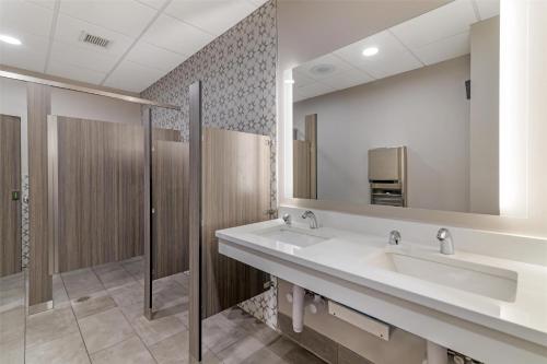 a bathroom with two sinks and a large mirror at Best Western Royal Plaza Hotel and Trade Center in Marlborough