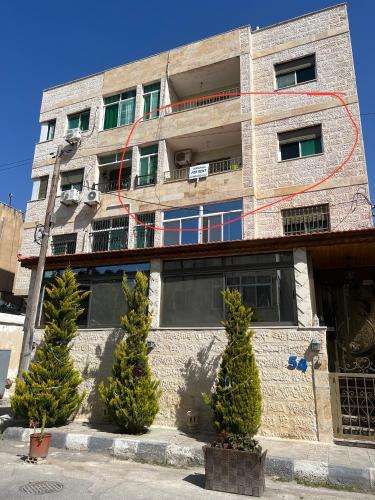 ein Backsteingebäude mit Bäumen davor in der Unterkunft Central affordable studio in Amman