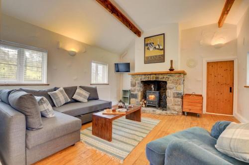 a living room with a couch and a fireplace at Ty Rowan in Trefriw