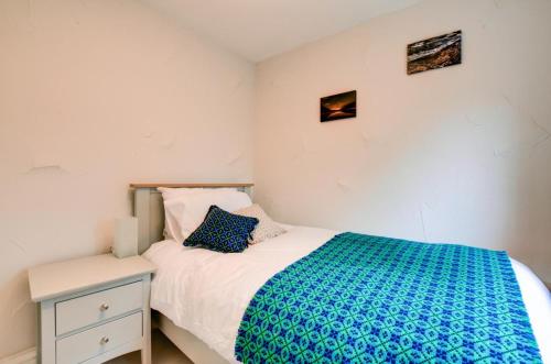 a small bedroom with a bed and a night stand at Ty Rowan in Trefriw