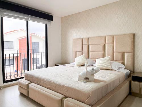 a bedroom with a large bed with a large window at Casa con Piscina Privada, Asadero Bbq y 4 cuartos en Guayaquil in Guayaquil