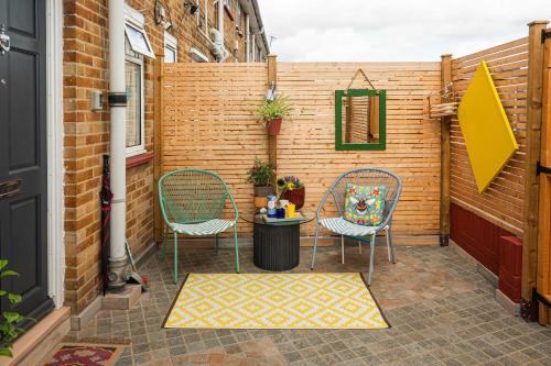 two chairs and a table on a patio at Garden Room Near Heathrow in Feltham