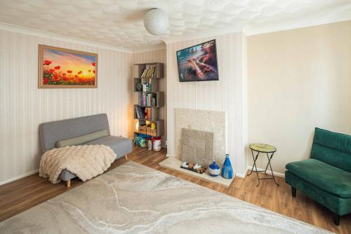 a living room with a couch and a fireplace at Garden Room Near Heathrow in Feltham