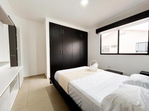 a bedroom with two beds and a window at Casa con Piscina Privada, Asadero Bbq y 4 cuartos en Guayaquil in Guayaquil