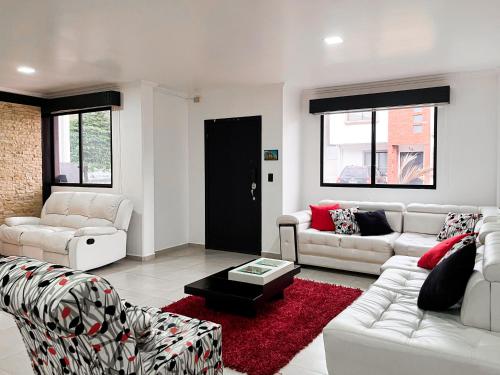 a living room with white furniture and a red rug at Casa con Piscina Privada, Asadero Bbq y 4 cuartos en Guayaquil in Guayaquil