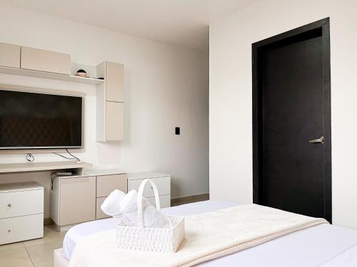 a bedroom with a bed and a flat screen tv at Casa con Piscina Privada, Asadero Bbq y 4 cuartos en Guayaquil in Guayaquil