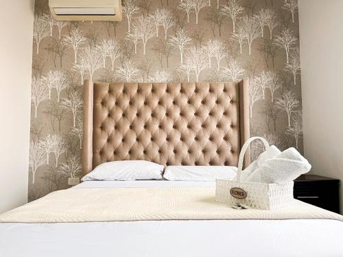 a large bed with a tufted headboard in a bedroom at Casa con Piscina Privada, Asadero Bbq y 4 cuartos en Guayaquil in Guayaquil