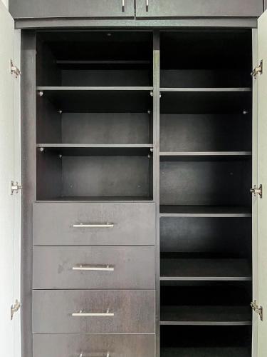 a closet with metal shelves and drawers at Casa con Piscina Privada, Asadero Bbq y 4 cuartos en Guayaquil in Guayaquil