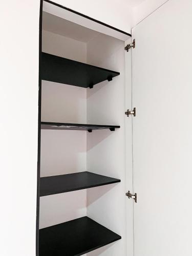 a closet with black shelves at Casa con Piscina Privada, Asadero Bbq y 4 cuartos en Guayaquil in Guayaquil