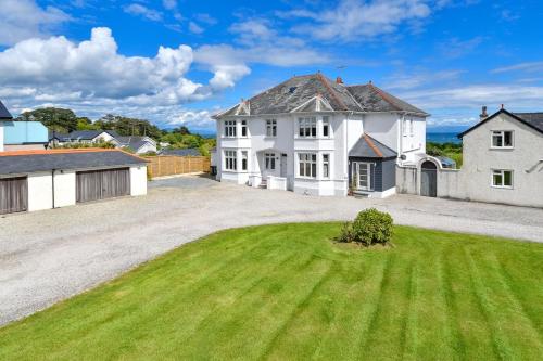 a large white house with a large yard at 1 Coed y Llyn in Abersoch