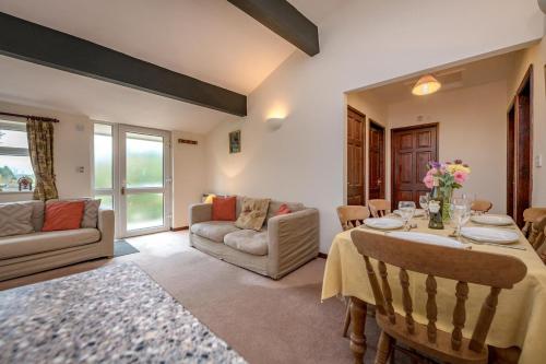 a living room with a table and a couch at Rose Cottage in Llanbedrog