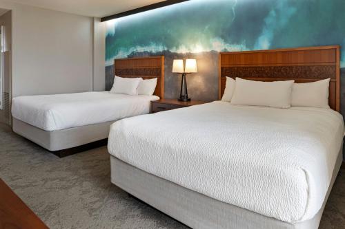 a hotel room with two beds and a painting on the wall at Courtyard by Marriott King Kamehameha's Kona Beach Hotel in Kailua-Kona