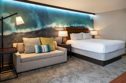a hotel room with a bed and a couch at Courtyard by Marriott King Kamehameha's Kona Beach Hotel in Kailua-Kona