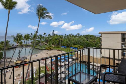 a view of the pool and beach from the balcony of a resort at Courtyard by Marriott King Kamehameha's Kona Beach Hotel in Kailua-Kona