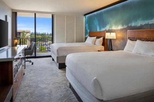 a hotel room with two beds and a balcony at Courtyard by Marriott King Kamehameha's Kona Beach Hotel in Kailua-Kona