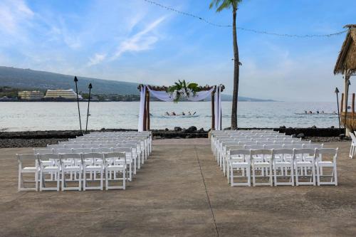 a row of white chairs in front of the water at Courtyard by Marriott King Kamehameha's Kona Beach Hotel in Kailua-Kona