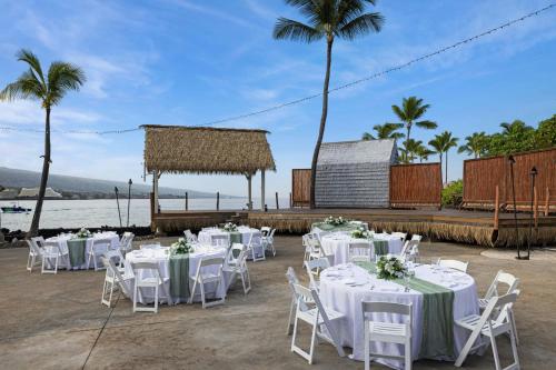 a wedding reception with white tables and chairs on the beach at Courtyard by Marriott King Kamehameha's Kona Beach Hotel in Kailua-Kona