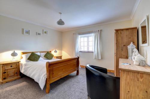 a bedroom with a bed and a desk with a chair at Ysgubor in Y Felinheli