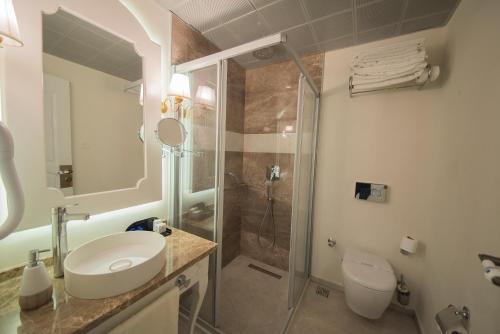 a bathroom with a shower and a sink and a toilet at Montebello Deluxe Hotel in Oludeniz