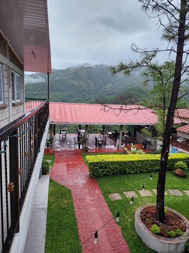a balcony of a house with a yard with birds at Hotel Risco Lodge in Valle de Ángeles