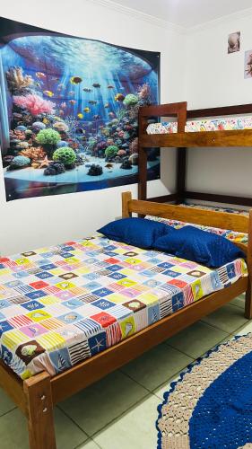 un letto in una camera con una foto sul muro di Pousada Mar e Sol a Peruíbe