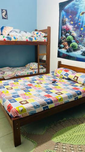 Una cama con una colcha encima en una habitación. en Pousada Mar e Sol, en Peruíbe