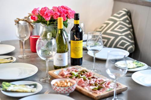 a table with two bottles of wine and a plate of food at Hillview in Llanbedrog