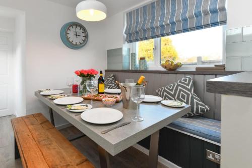 a kitchen with a table and a clock on the wall at Hillview in Llanbedrog