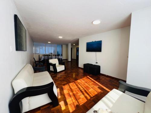 a living room with white furniture and a wooden floor at Santa Clara Apartment 3 Bedroom 2 Bath in Baños