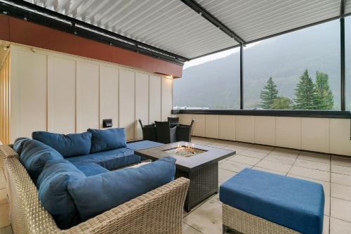 a living room with blue couches and a table at 1BR Lakeside Getaway on Harrison Lake in Harrison Hot Springs