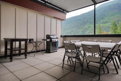 a room with a table and chairs and a stove at 1BR Lakeside Getaway on Harrison Lake in Harrison Hot Springs