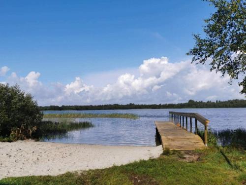 a wooden bench sitting on the side of a lake at 6 person holiday home in Ansager-By Traum in Ansager