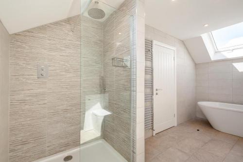 ein Badezimmer mit Dusche, Badewanne und Waschbecken in der Unterkunft Yr Hen Barlwr in Llanddyfnan