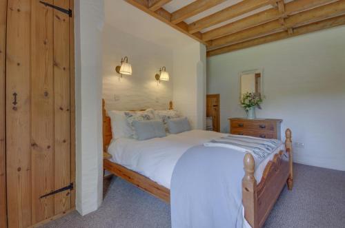 een slaapkamer met een groot wit bed en een houten deur bij Mole Cottage in Parracombe