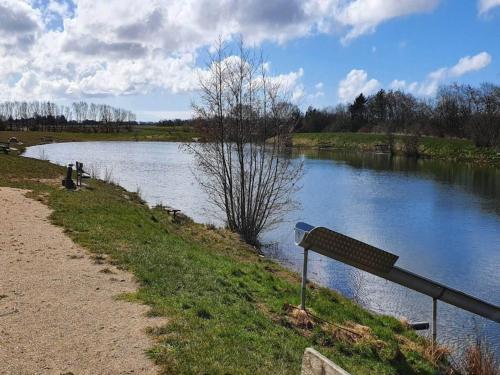 a bench on the side of a river at 6 person holiday home in Oksbøl-By Traum in Oksbøl