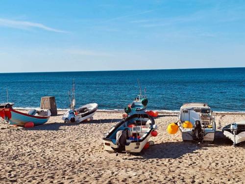 a group of boats sitting on a beach at 6 person holiday home in Thisted-By Traum in Torsted