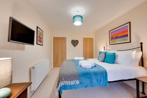 a bedroom with a large bed and a flat screen tv at Pwllglas in Darowen