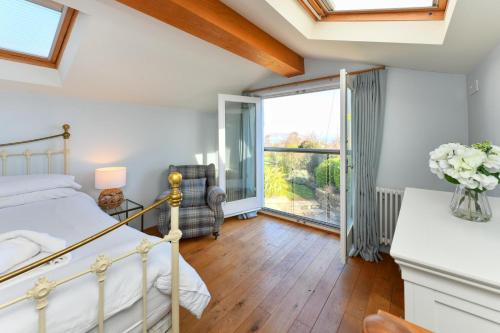 a bedroom with a bed and a large window at Pengarth Cottage in Abersoch