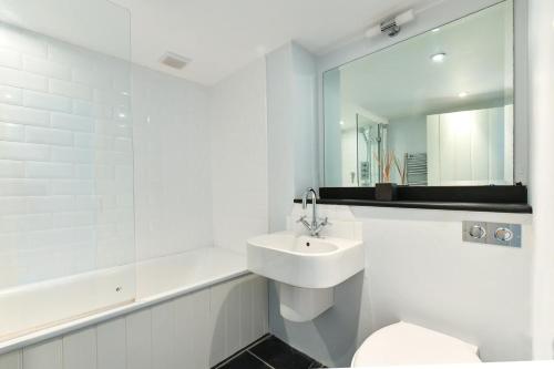 a white bathroom with a sink and a toilet at Pengarth Cottage in Abersoch