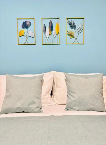 a bed with four pictures on a blue wall at Deborah's House in Ercolano