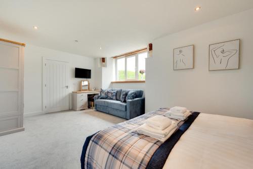 a bedroom with a bed and a couch at Neptune in Saundersfoot