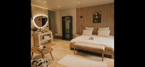 a bedroom with a bed and a mirror and a table at Da Mona in Reims