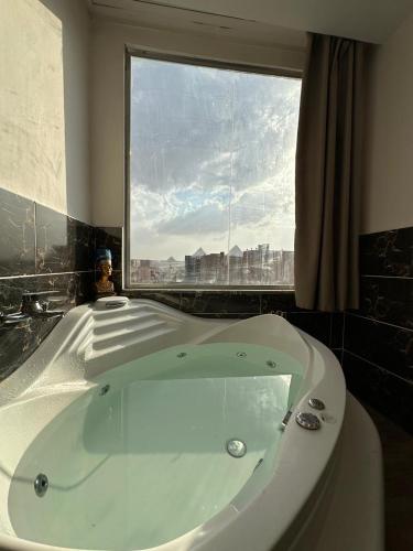 a bath tub in a bathroom with a window at king pyramids in Cairo
