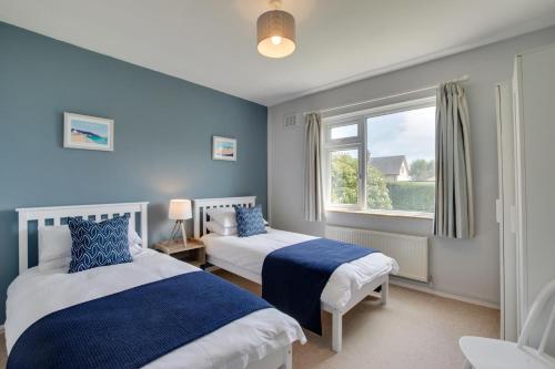 une chambre avec deux lits et une fenêtre dans l'établissement Ty Gwyn, à Llanbedrog