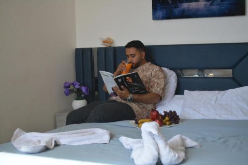 a man sitting on a bed reading a book at king pyramids in Cairo